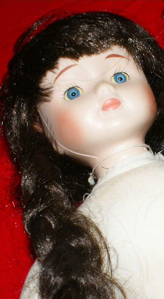 Photo d'une poupée brune en porcelaine.